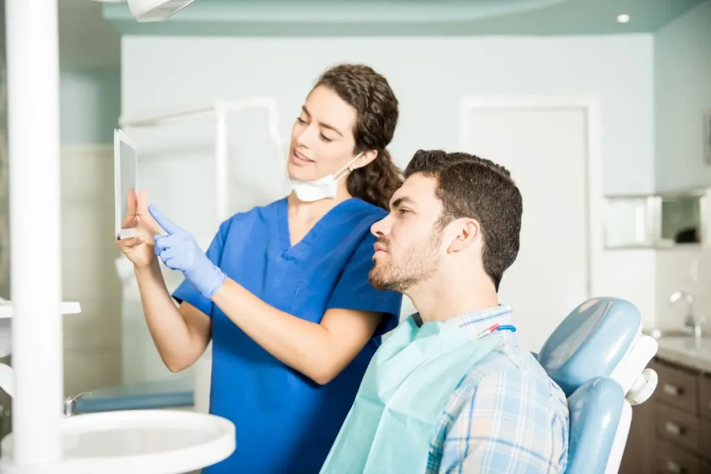 Paciente y odontóloga mostrando espejo en clínica dental en Lima