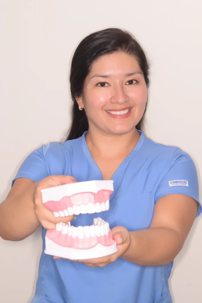 Odontóloga de Arte y sonrisas sosteniendo maqueta de los dientes